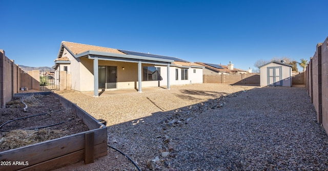 back of property featuring a shed and a patio area