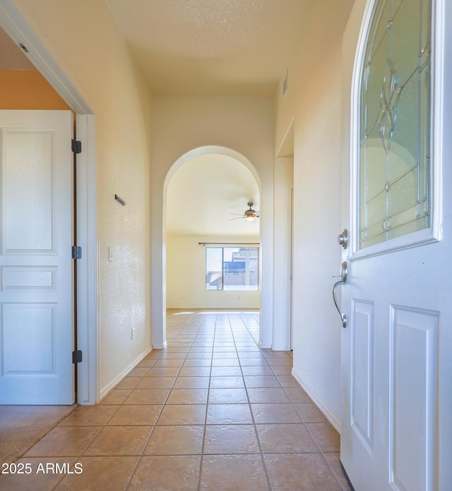 hallway featuring a textured ceiling and light tile patterned floors