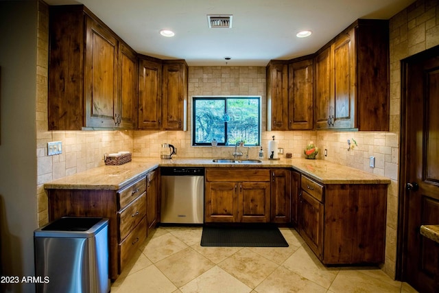 kitchen with sink, tasteful backsplash, light stone counters, light tile patterned floors, and dishwasher