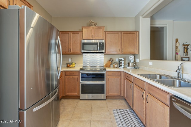 kitchen with tasteful backsplash, sink, light tile patterned floors, and stainless steel appliances