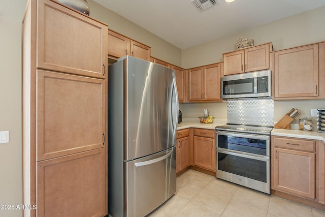 kitchen featuring decorative backsplash, light brown cabinets, light tile patterned floors, and stainless steel appliances