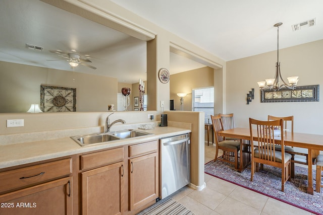 kitchen with dishwasher, sink, pendant lighting, light tile patterned flooring, and ceiling fan with notable chandelier