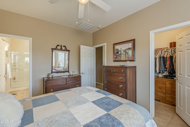 tiled bedroom featuring ceiling fan, a spacious closet, connected bathroom, and a closet