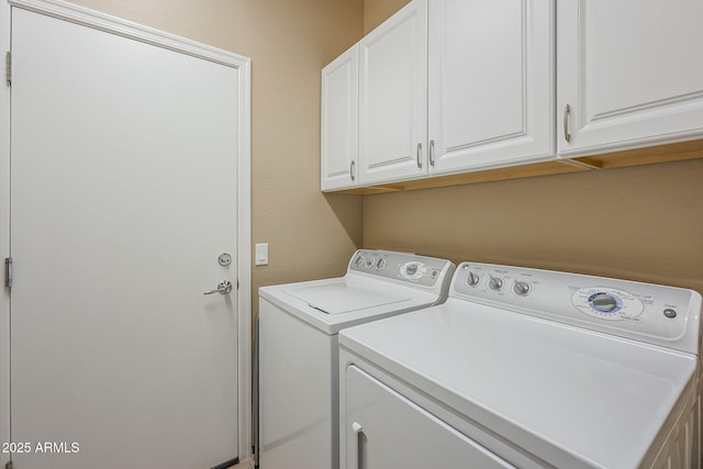 clothes washing area featuring cabinets and washing machine and dryer