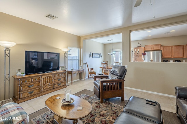 living room with light tile patterned floors and ceiling fan with notable chandelier