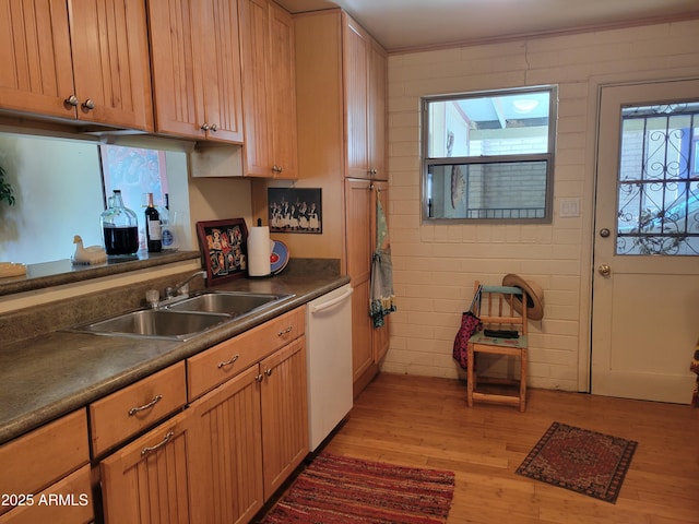 kitchen featuring sink, light wood-type flooring, dishwasher, and brick wall