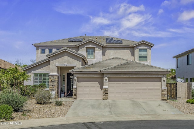 43650 W Snow Dr, Maricopa, AZ 85138 - view of front of home featuring stone siding, roof mounted solar panels, a garage, a tile roof, and driveway