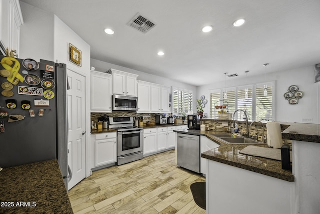 43650 W Snow Dr, Maricopa, AZ 85138 - kitchen featuring light wood-type flooring, stainless steel appliances, backsplash, a sink, and visible vents
