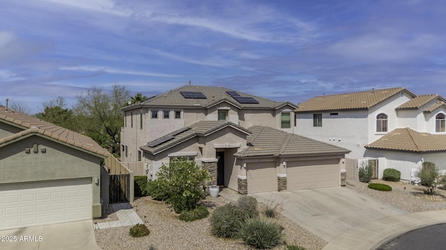 43650 W Snow Dr, Maricopa, AZ 85138 - view of front of house featuring driveway, a tiled roof, an attached garage, solar panels, and stucco siding