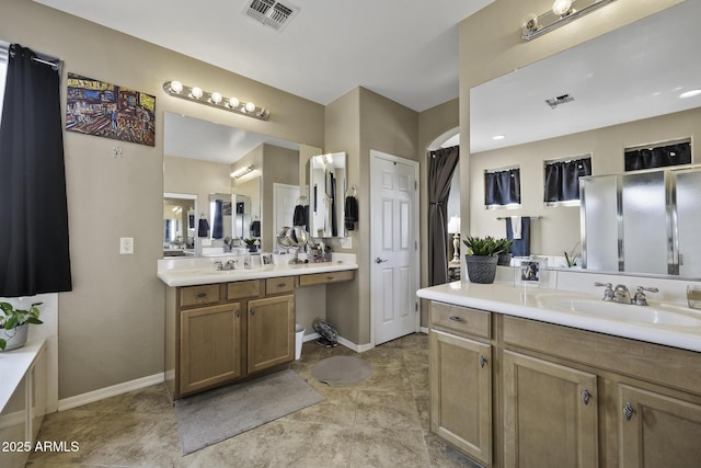 43650 W Snow Dr, Maricopa, AZ 85138 - bathroom with baseboards, visible vents, a sink, and two vanities