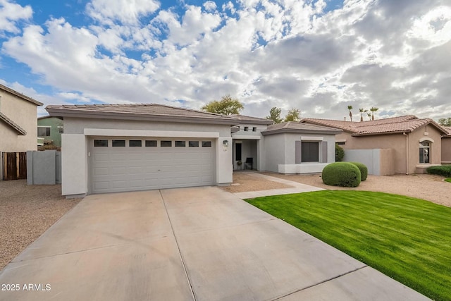 prairie-style house featuring concrete driveway, a tiled roof, a garage, and stucco siding