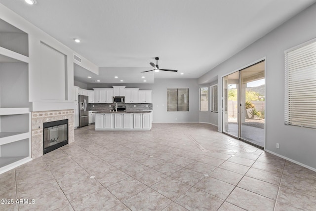 unfurnished living room with light tile patterned flooring, visible vents, ceiling fan, and recessed lighting