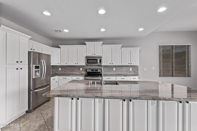 kitchen with white cabinets, recessed lighting, stainless steel appliances, a spacious island, and decorative backsplash