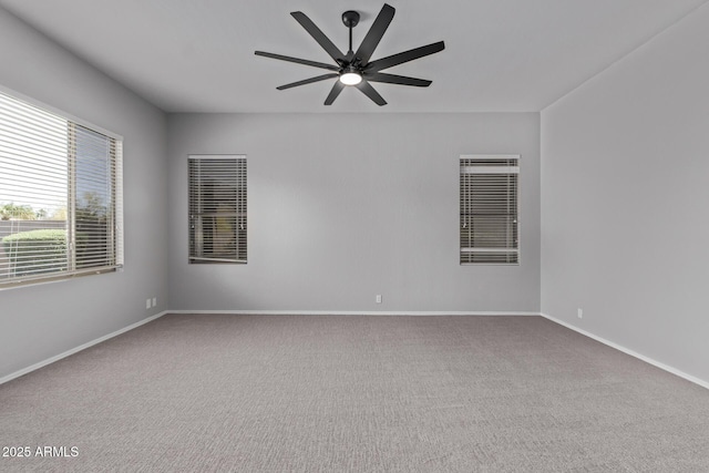 carpeted empty room with ceiling fan and baseboards