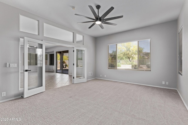 empty room featuring carpet floors, baseboards, ceiling fan, and french doors
