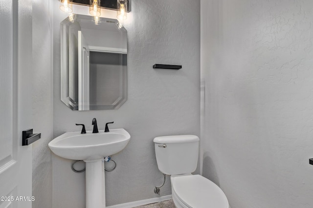 half bathroom featuring toilet and a sink