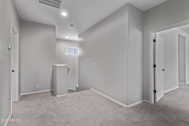 carpeted spare room featuring recessed lighting, visible vents, and baseboards