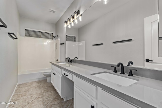 bathroom featuring visible vents, a sink, double vanity, and toilet