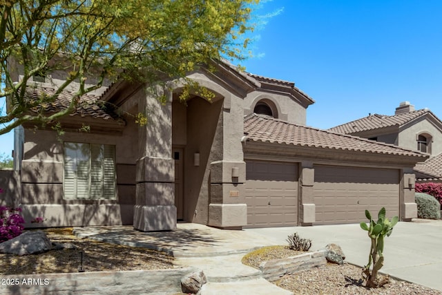 view of front of home featuring a garage, stucco siding, a tiled roof, and concrete driveway