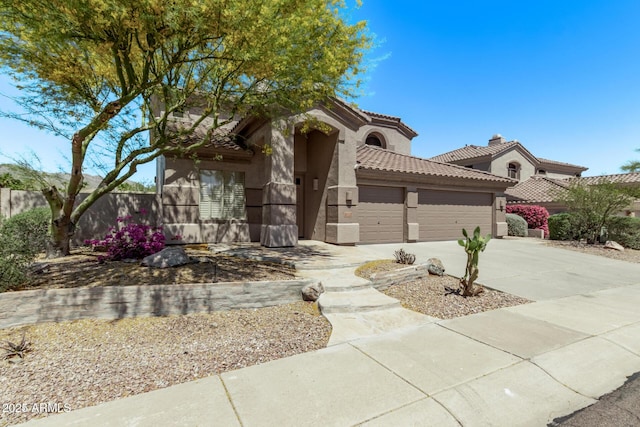 mediterranean / spanish house with driveway, a tiled roof, an attached garage, fence, and stucco siding