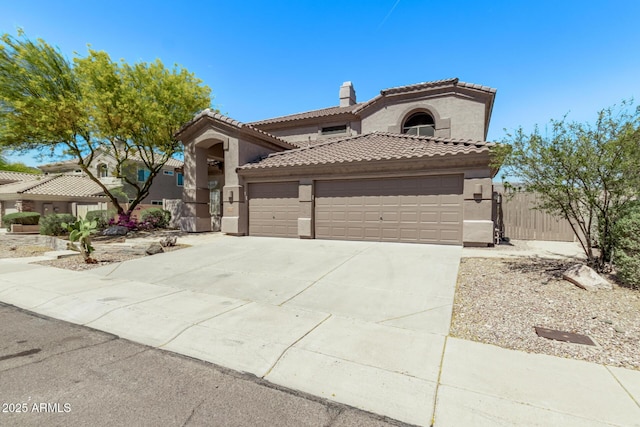mediterranean / spanish home with a chimney, concrete driveway, an attached garage, a tile roof, and stucco siding