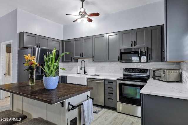 2926 W Smoketree St, Apache Junction, AZ 85120 - kitchen with stainless steel appliances, ceiling fan, decorative backsplash, a sink, and light wood finished floors