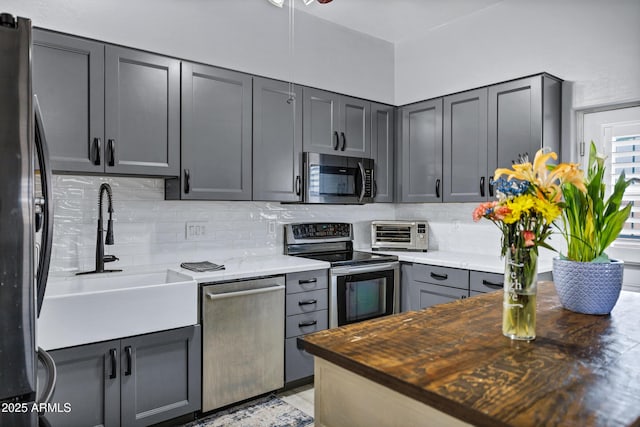 2926 W Smoketree St, Apache Junction, AZ 85120 - kitchen featuring stainless steel appliances, a sink, backsplash, and gray cabinetry