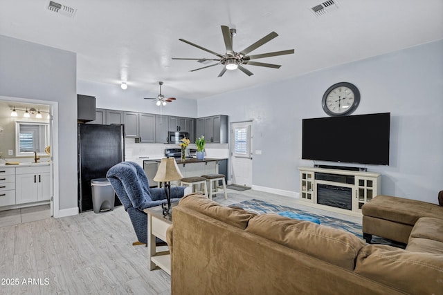 2926 W Smoketree St, Apache Junction, AZ 85120 - living room featuring a ceiling fan, light wood-type flooring, and baseboards