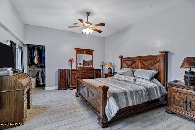 2926 W Smoketree St, Apache Junction, AZ 85120 - bedroom with light wood finished floors, a closet, a walk in closet, a ceiling fan, and baseboards