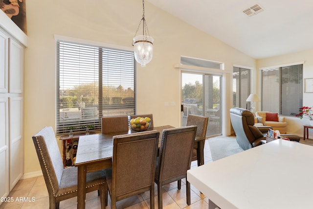 tiled dining space with vaulted ceiling, a notable chandelier, and french doors