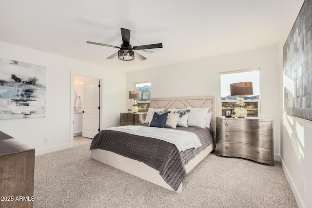 carpeted bedroom featuring ceiling fan and ensuite bath