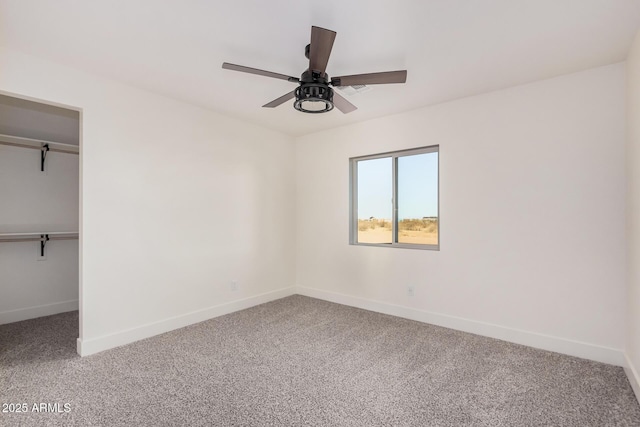 unfurnished bedroom featuring carpet, a spacious closet, ceiling fan, and a closet