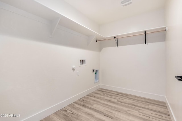 clothes washing area featuring gas dryer hookup, washer hookup, light hardwood / wood-style flooring, and electric dryer hookup