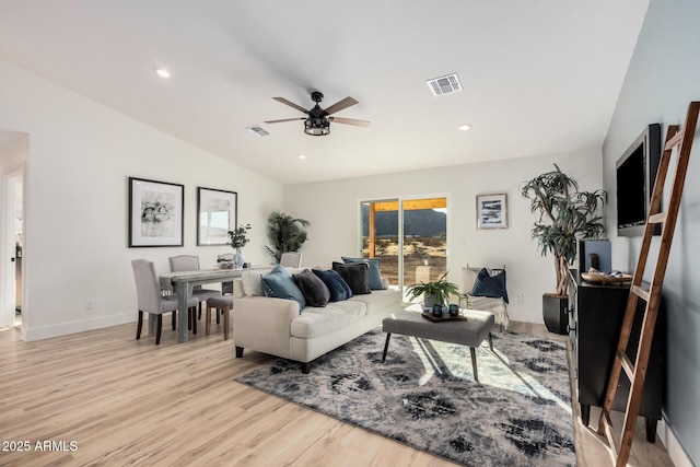 living room featuring ceiling fan, lofted ceiling, and light hardwood / wood-style floors