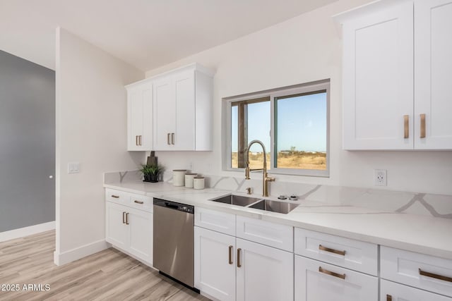 kitchen with sink, white cabinetry, light stone counters, light hardwood / wood-style flooring, and dishwasher