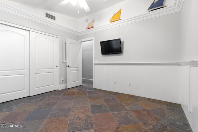 unfurnished bedroom with ceiling fan and a closet