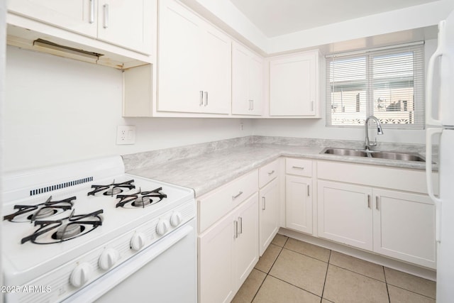 kitchen featuring white appliances, light tile patterned flooring, a sink, light countertops, and white cabinetry
