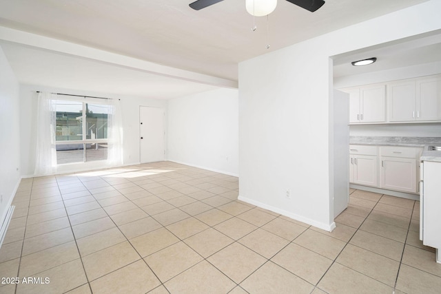 empty room featuring light tile patterned floors, baseboards, and ceiling fan
