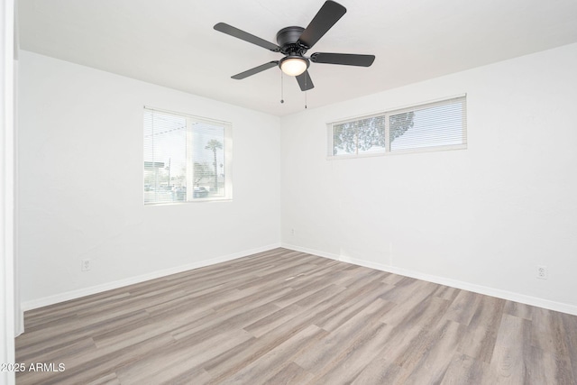 unfurnished room with baseboards, wood finished floors, and a ceiling fan