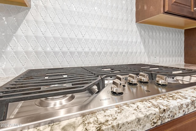 interior details with decorative backsplash and stainless steel gas stovetop