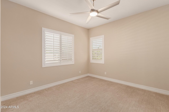 spare room featuring light colored carpet and ceiling fan