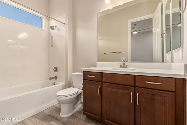 full bathroom with ceiling fan,  shower combination, toilet, vanity, and hardwood / wood-style flooring