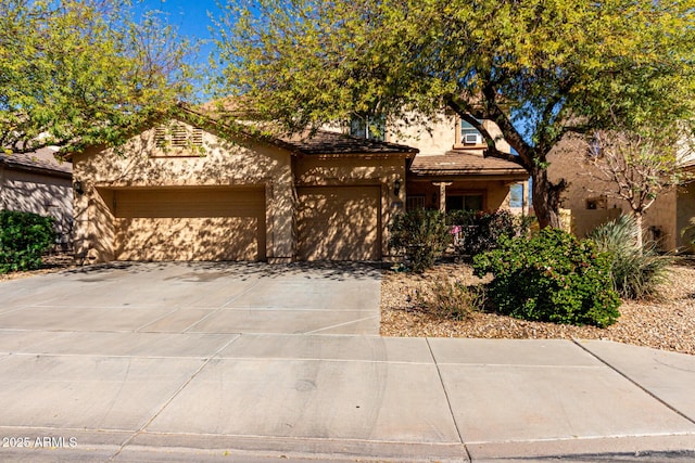 view of front of house featuring a garage, concrete driveway, a tiled roof, and stucco siding