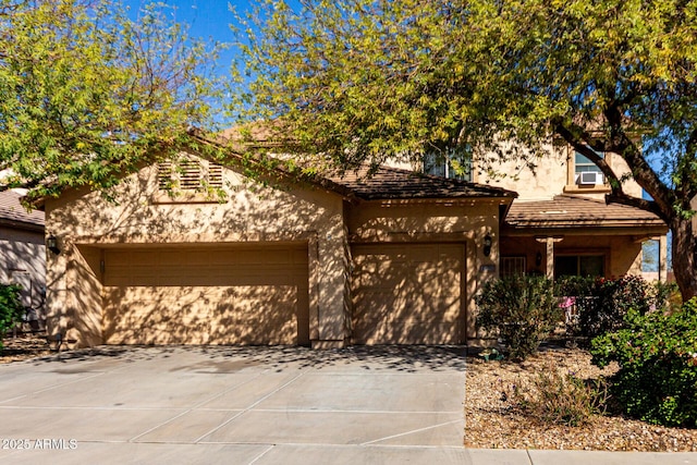 view of front of house with a garage, driveway, and stucco siding