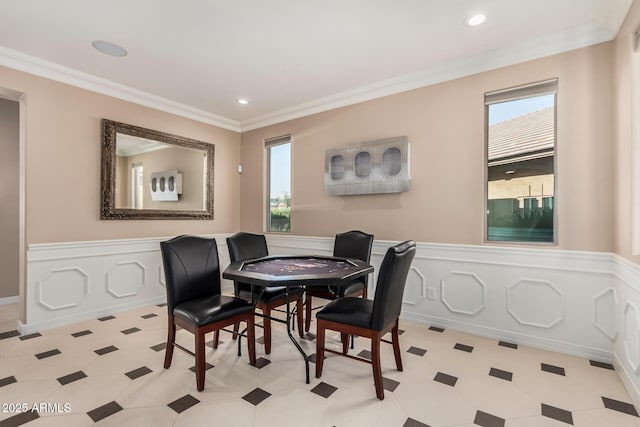 dining area featuring recessed lighting, a wainscoted wall, crown molding, and a decorative wall