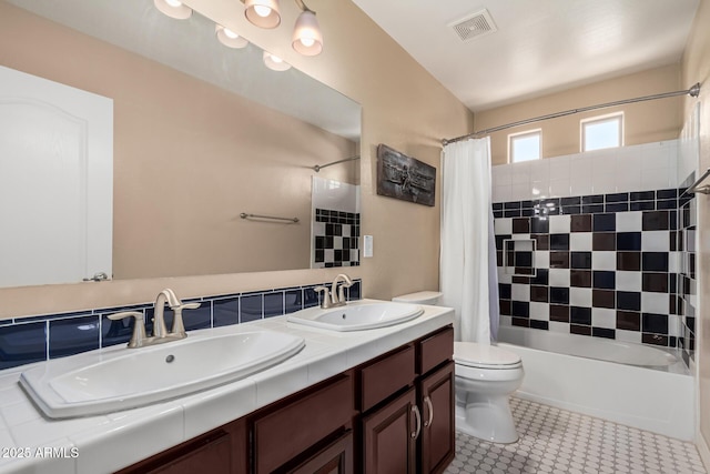 bathroom featuring toilet, shower / bath combo, visible vents, and a sink