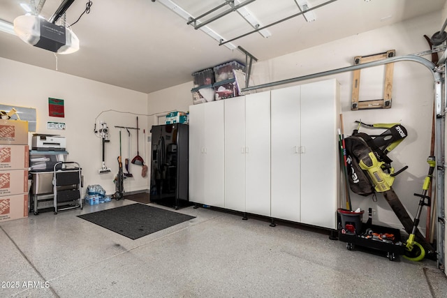 garage with black fridge with ice dispenser and a garage door opener