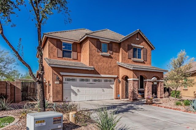 view of front of property featuring a tiled roof, an attached garage, driveway, and fence