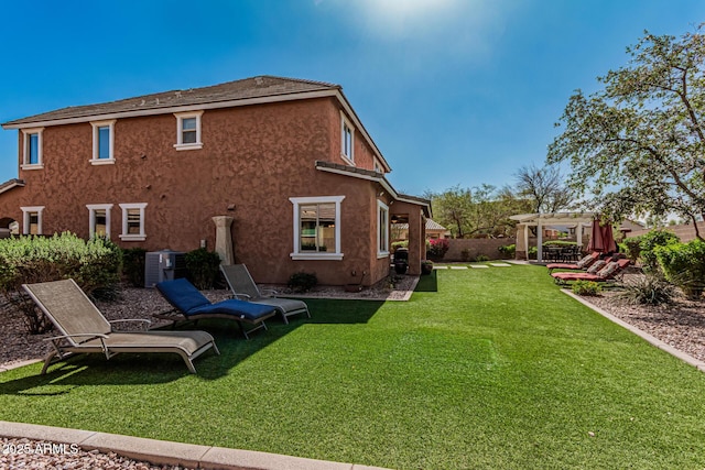 back of house featuring central AC unit, fence, a pergola, stucco siding, and a lawn