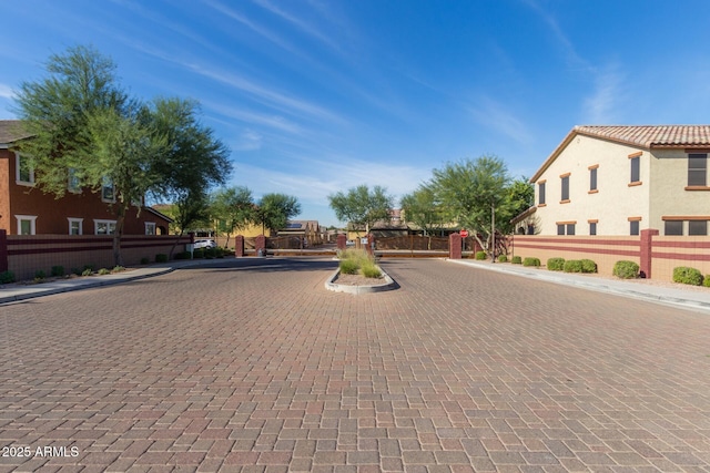 view of street featuring a gate, curbs, sidewalks, and a gated entry